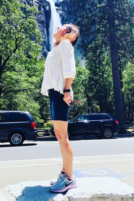Demetria Clemons in front of a roadside waterfall in Yosemite