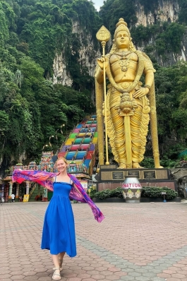 A photo of Lex posting with a statue in Malaysia.