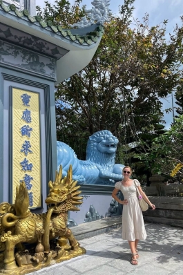 A photo of Lex posing in front of a structure in Vietnam.
