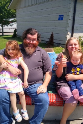 Adam Storm and family seated on a colorful tile mosaic bench