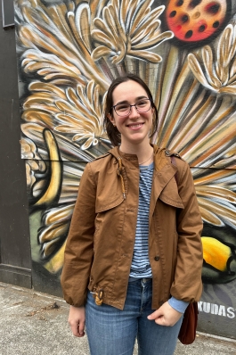 Amanda Pfeil smiling in front of a mural that looks vaguely floral