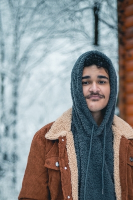 A picture of Andy next to a cabin in snowy Tennessee