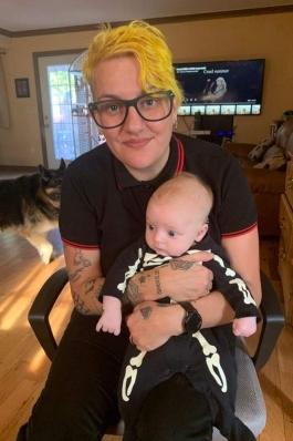 A picture of Lori holding a baby in a home.