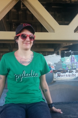 A photo of Lori sitting outside a skate park.