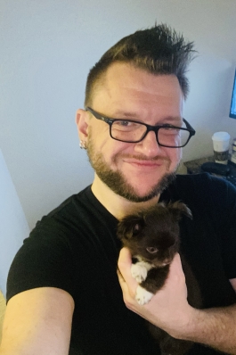 A selfie of Jason holding a puppy.