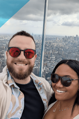 A photo of Josh and his partner with the NYC skyline in the background.