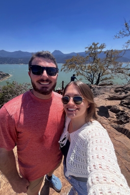 A photo of Victoria and someone above a lake.