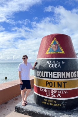 A photo of August posing with the southernmost point in the U.S.