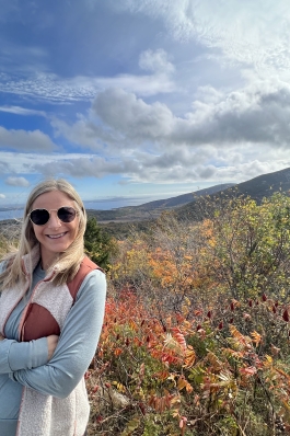 Lexie posing with the Maine mountainside behind her.